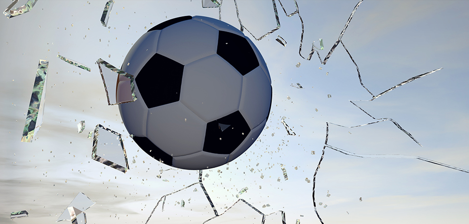 Fußball durchbricht eine Glasscheibe – Scherben fliegen in alle Richtungen.