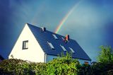 Wie sinnvoll ist eine Wohngebäudeversicherung? Sie schützt das abgebildete Haus mit Spitzdach, unter blauem Himmel und schönen Regenbogen. Das Haus ist abgesichert durch die Wohngebäudeversicherung der GEV. 