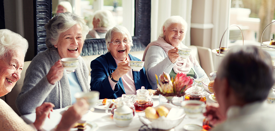 Alte Damen sitzen sehr fröhlich beim Kaffeekränzchen im Seniorenheim. Den alten Damen geht es gut. So etwas wünschen wir uns auch fürs Alter.  