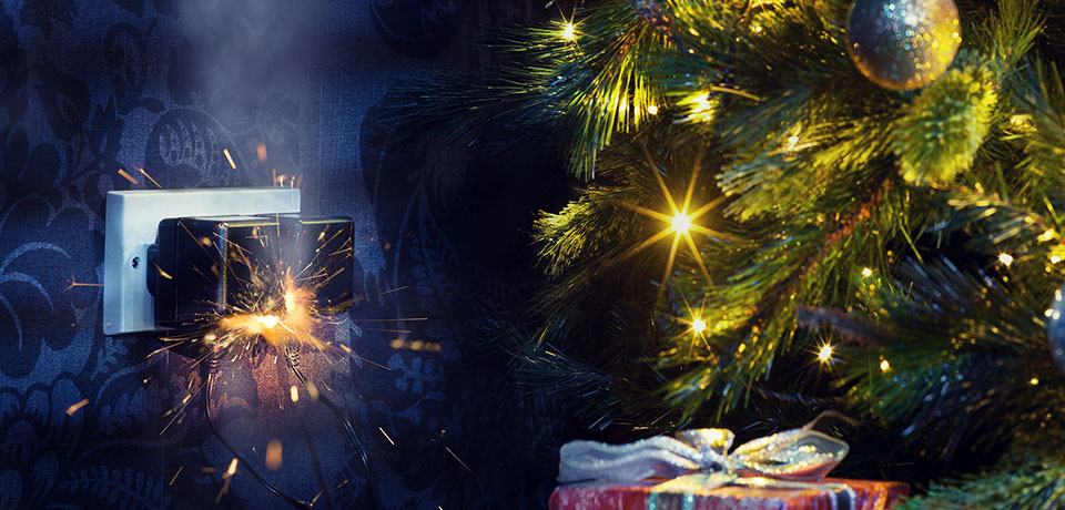 Brandgefahr durch unsichere Netzteile. Im Bild die Lichterkette eines Weihnachtsbaums, das Netzteil sprüh Funken. 