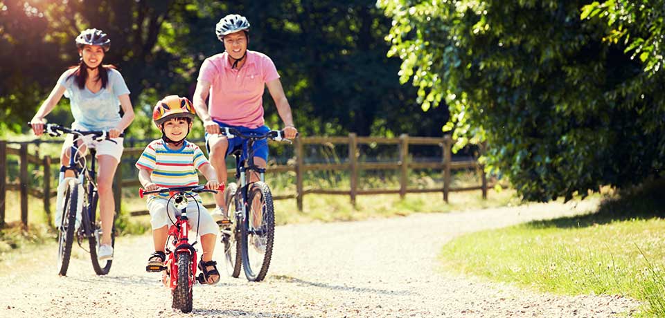 Junge Familie auf Fahrrädern bei einem Wochenendausflug. Fahrraddiebstähle können meistens verhindert werden. Wir zeigen wie.   