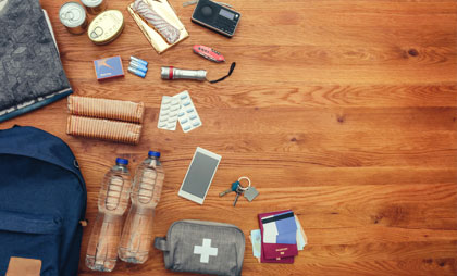 Gegenstände die in einen Notfallrucksackgehören ausgebreitet auf dem Boden
