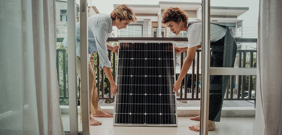 Solarpanel ausrichten, einstöpeln, fertig ist das Balkonkraftwerk. Zwei Frauen richten das Solarpanel auf ihrem Balkon aus. Sie müssen es nur noch einstöpseln und anmelden.