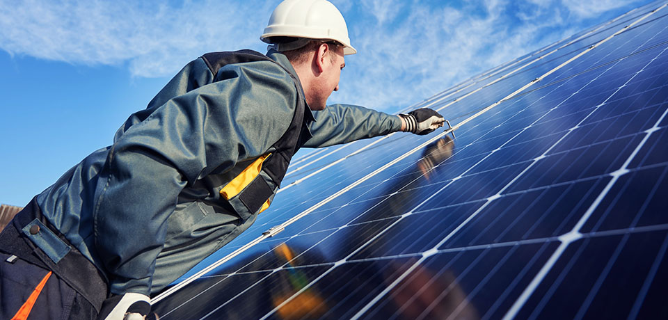 Monteur installiert fachmännisch eine Solaranlage. In vielen Bundesländern besteht bereits eine Solarpflicht bei Neubauten. 