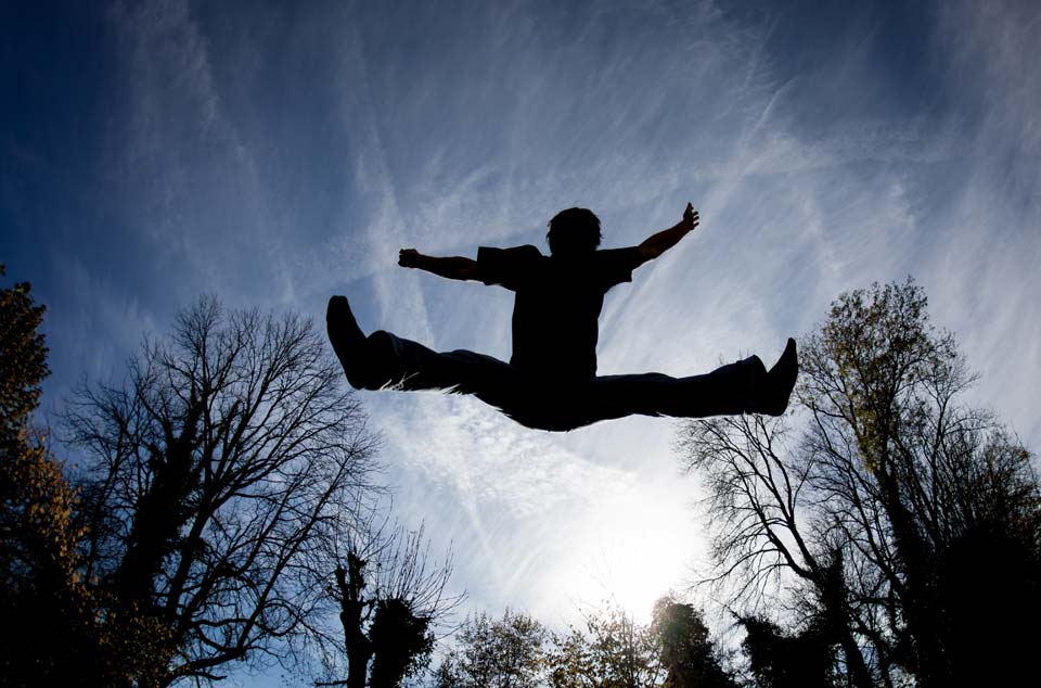 Ein Kind springt auf einem Trampolin durch die Luft. Aber was passiert bei Sturm mit dem Trampolin?